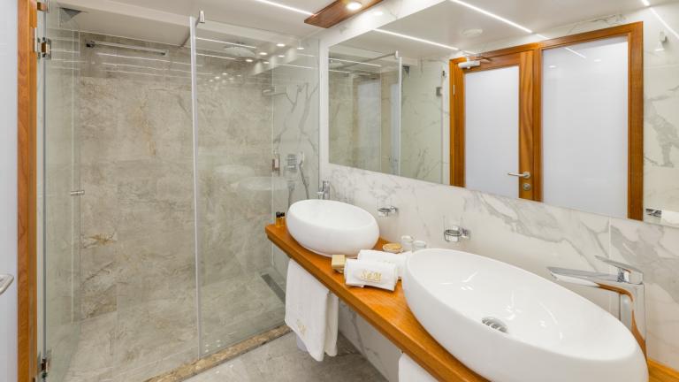 A bright bathroom with a ground-level XXL rain shower in the master cabin of the Son de Mar.